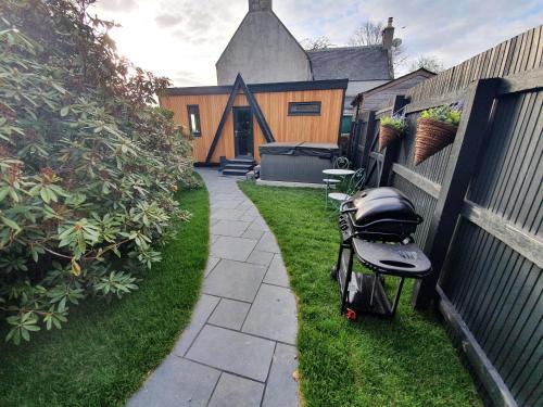 a stroller sitting on the grass next to a fence at Little Woodbine in Tain