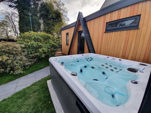 a hot tub on the side of a house at Little Woodbine in Tain