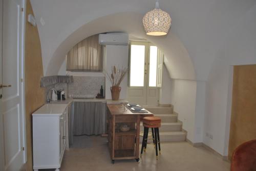 Casetta Melograno في فاسانو: مطبخ مع ممر وطاولة في غرفة