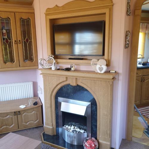a living room with a fireplace with a tv above it at Home from home private host in Skegness