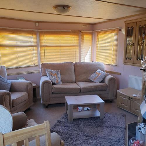 Sala de estar con 2 sofás y mesa de centro en Home from home private host en Skegness