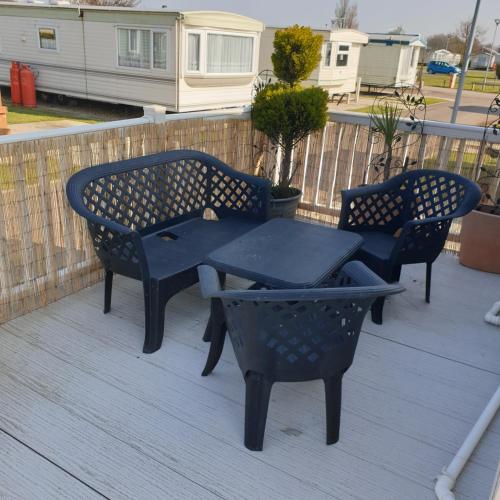 a picnic table and two chairs on a deck at Home from home private host in Skegness