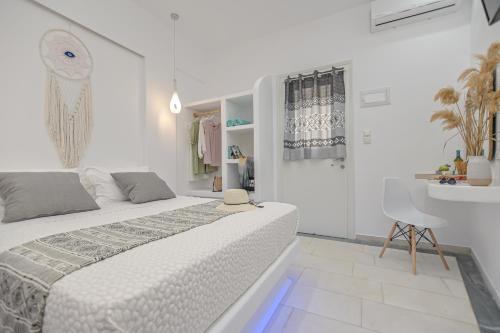 biała sypialnia z łóżkiem i umywalką w obiekcie Jardin De Castillo , Naxos Town w mieście Naksos