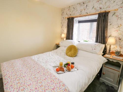 a bedroom with a bed with two plates of food on it at The Lodge in Whitby