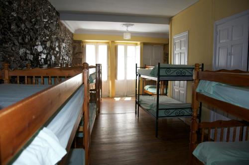 a room with three bunk beds and a window at Albergue los Blasones in Sarria