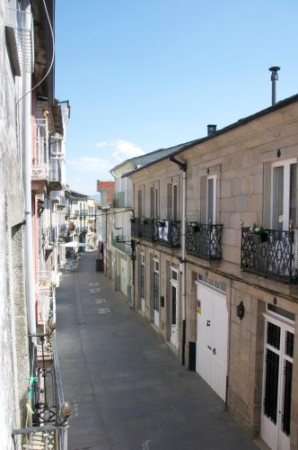 an empty street in an alley between buildings at Albergue los Blasones in Sarria