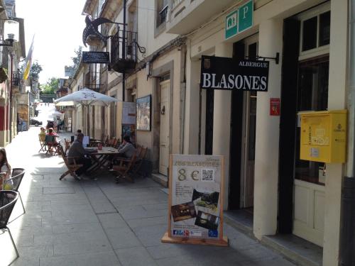 a street with people sitting at tables outside a restaurant at Albergue los Blasones in Sarria