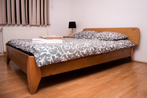 - une chambre avec un lit doté d'un cadre de lit en bois dans l'établissement Butterfly Apartment-Hidden Gem in the Heart of Targu Mures, à Târgu-Mureş
