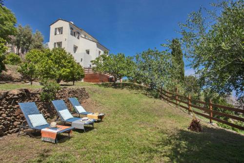 a group of chairs sitting on a hill next to a house at vita nova in Santa-Maria-di-Lota