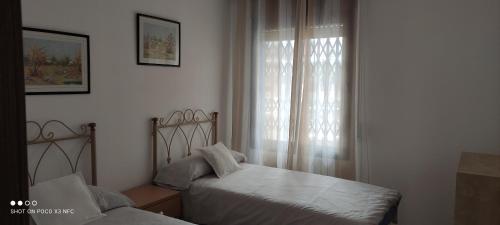 a bedroom with two beds and a window at apartamento Anais in Salou