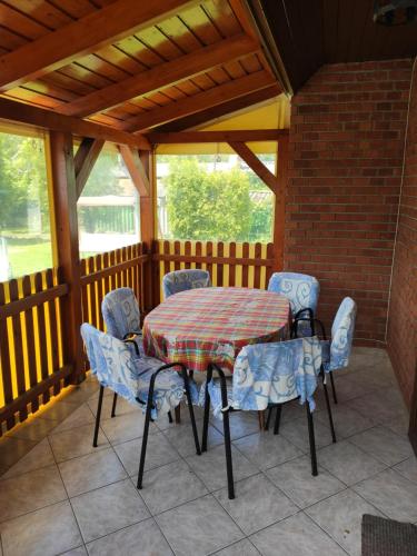 una mesa y sillas en el porche de una casa en Vitorlás Haus, en Balatonkeresztúr