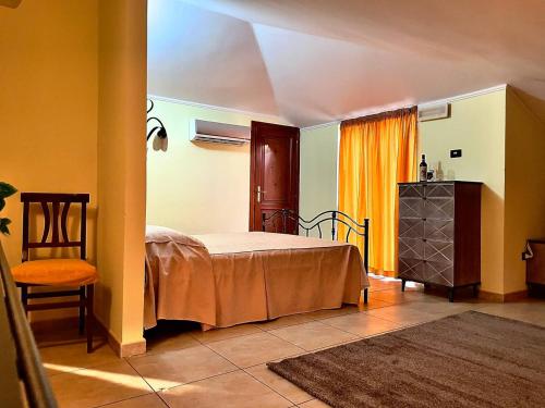 ein Schlafzimmer mit einem Bett und einem Stuhl in einem Zimmer in der Unterkunft Hotel La Cometa in Diamante