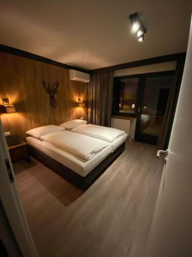 una camera da letto con un grande letto bianco di Dahoam by Sarina - Village Appartements a Zell am See