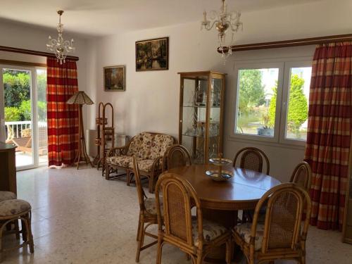 uma sala de estar com uma mesa de jantar e cadeiras em Sea front villa Natalia em Agia Napa