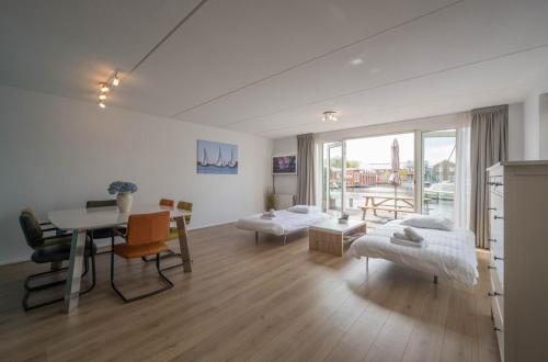 UitgeestにあるMeerzicht 70 - Vakantiehuis aan het water!のテーブルとダイニングルームのあるリビングルーム