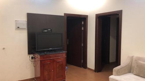 Una televisión o centro de entretenimiento en Bait Alsadaqa Aparthotel
