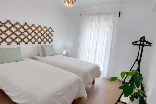 a bedroom with two beds and a plant in it at Casa 37 - Country Home in Terrugem