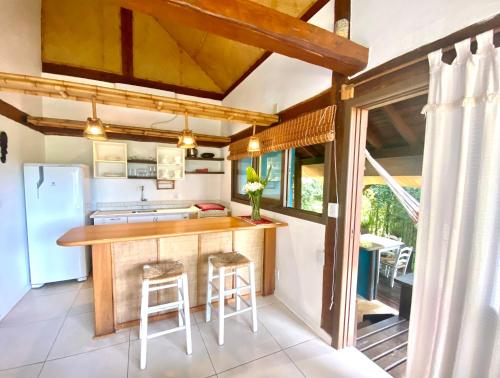 a kitchen with a counter and a refrigerator at Pousada Bungalow in Praia do Rosa
