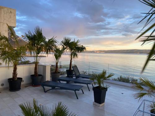a patio with benches and a view of the water at Apartment Anastazija in Omiš