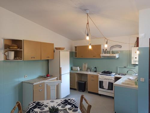 a kitchen with wooden cabinets and a white refrigerator at Surf & Kite - Villa Nortada in Charneca