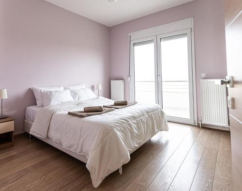 1 dormitorio blanco con 1 cama grande y ventana grande en Modern apartment with wonderful view, en Epanomí