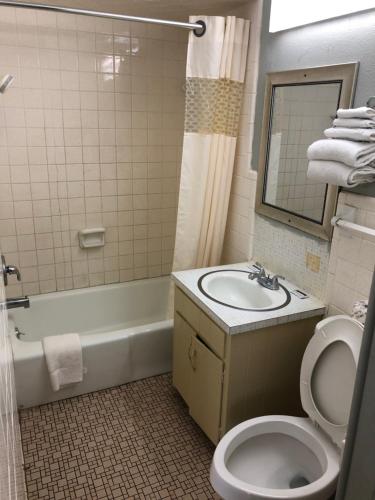 a bathroom with a sink and a toilet and a tub at Budget inn in Kingsville