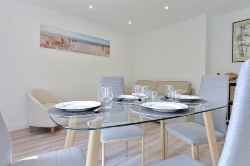 une salle à manger avec une table et des chaises en verre dans l'établissement Charming 2-Room Apartment in the City Center, à Cannes