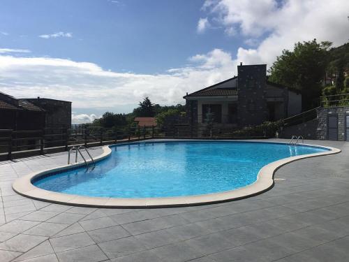 une grande piscine bleue avec un bâtiment en arrière-plan dans l'établissement Armonie del Lago, à Baveno