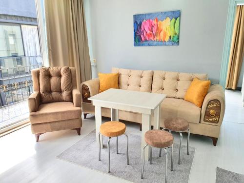 a living room with a couch and a table and chairs at Home Mood Apart Hotel in Antalya
