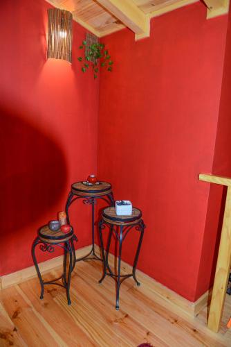two tables in a room with a red wall at Casa dos Alcaides in Sabugueiro