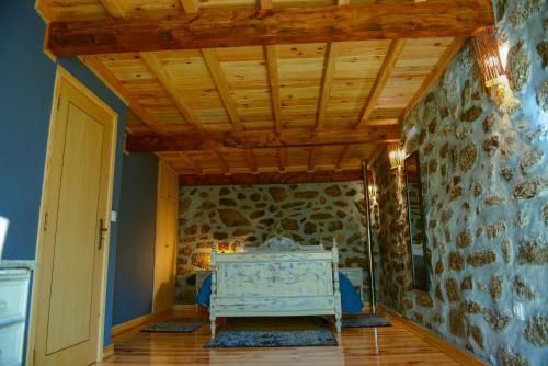 a room with a bed and a stone wall at Casa dos Alcaides in Sabugueiro
