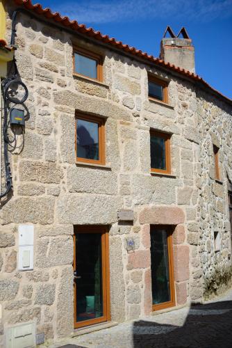 a stone building with windows on the side of it at Casa dos Alcaides in Sabugueiro