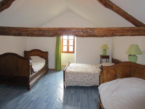 une chambre avec deux lits et une fenêtre dans l'établissement Grand Gîte à la ferme, à Les Costes-Gozon