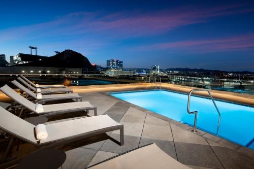 a pool on the roof of a building with lounge chairs at Hyatt House Tempe Phoenix University in Tempe