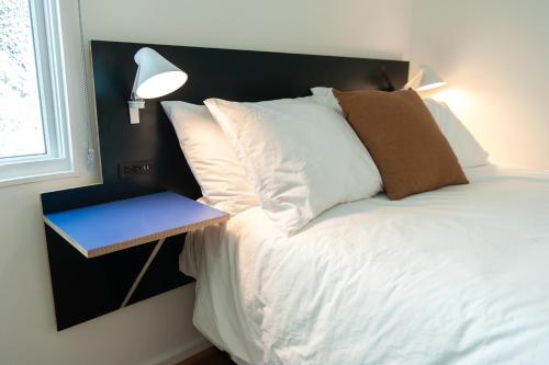 a bed with white pillows and a night stand next to a window at Travelers New Orleans in New Orleans