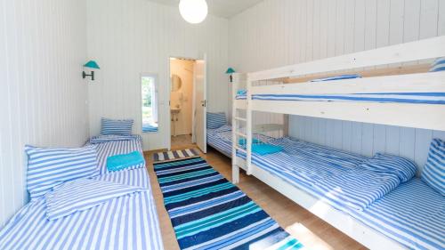 two bunk beds in a room with blue and white stripes at Puhkekeskus Valkla Rand- Simple accomodation in Valkla