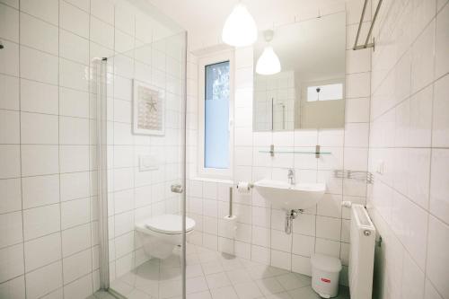 a white bathroom with a toilet and a sink at Velden - Villa right in the center with private parking in Velden am Wörthersee