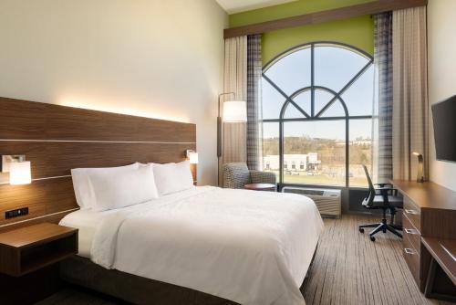 een hotelkamer met een bed en een groot raam bij Holiday Inn Express Hotel & Suites Opelika Auburn, an IHG Hotel in Opelika