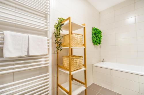 La salle de bains est pourvue d'une étagère d'or et d'une baignoire. dans l'établissement Apartament Smarald, à Braşov