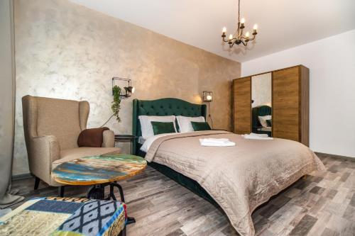 een slaapkamer met een groot bed en een stoel bij Apartament Smarald in Braşov