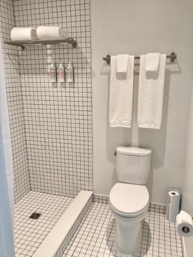 a bathroom with a toilet and a shower with towels at Travelers New Orleans in New Orleans