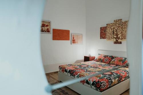 una camera da letto con un letto con copriletto floreale di La casetta di Nonna Giovanna a Noci