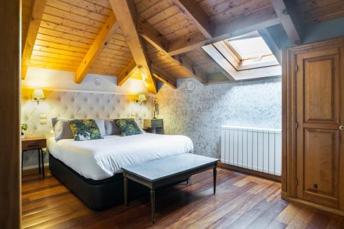 um quarto com uma cama e uma clarabóia em El Torreon de Navacerrada em Navacerrada