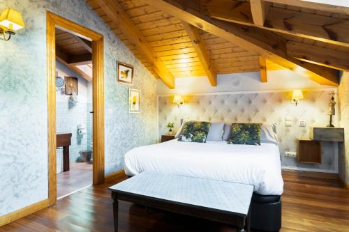 a bedroom with a king sized bed and a bathroom at El Torreon de Navacerrada in Navacerrada