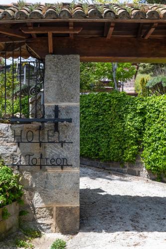 a sign for a hotel tooren under a woodenilion at El Torreon de Navacerrada in Navacerrada