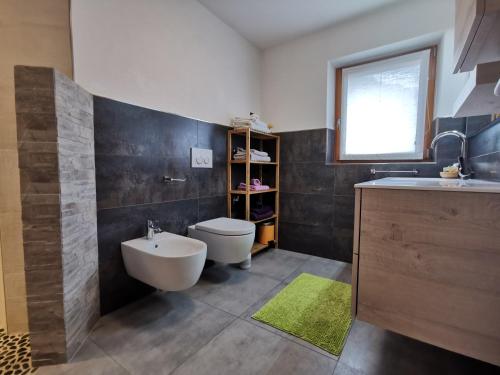 a bathroom with a white toilet and a sink at Appartamento Engy in Livigno