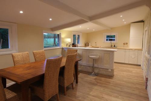 une cuisine avec une table et des chaises de salle à manger en bois dans l'établissement Le Clos Valentine, à Le Torquesne