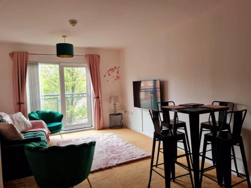 uma sala de estar com uma mesa e cadeiras e uma televisão em Emerald Blossom-Central Warrington, Luxurious Yet Homely, WiFi, Secure Parking em Warrington