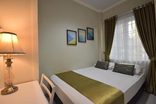 Nest Residence في جاكرتا: غرفة نوم بسرير ومصباح وطاولة