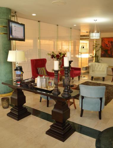 a living room with a table with candles and chairs at Hotel San Luis Lindavista in Culiacán